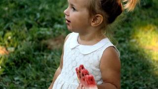 Una bambina con una fetta di anguria