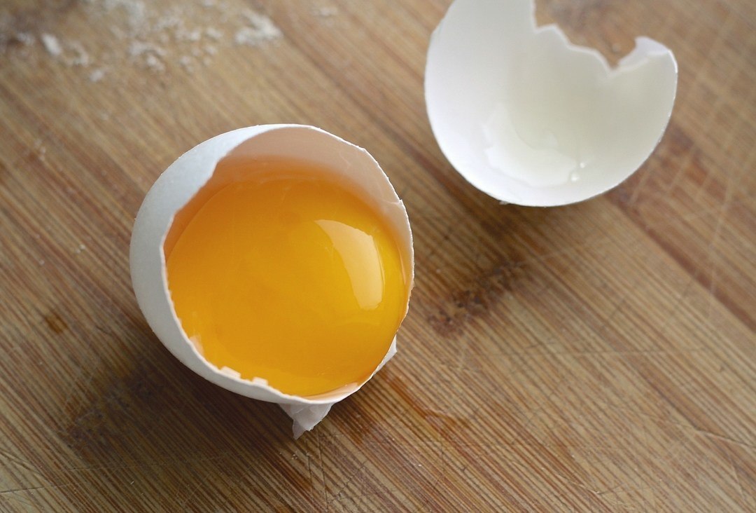 Un uovo aperto e il suo tuorlo
